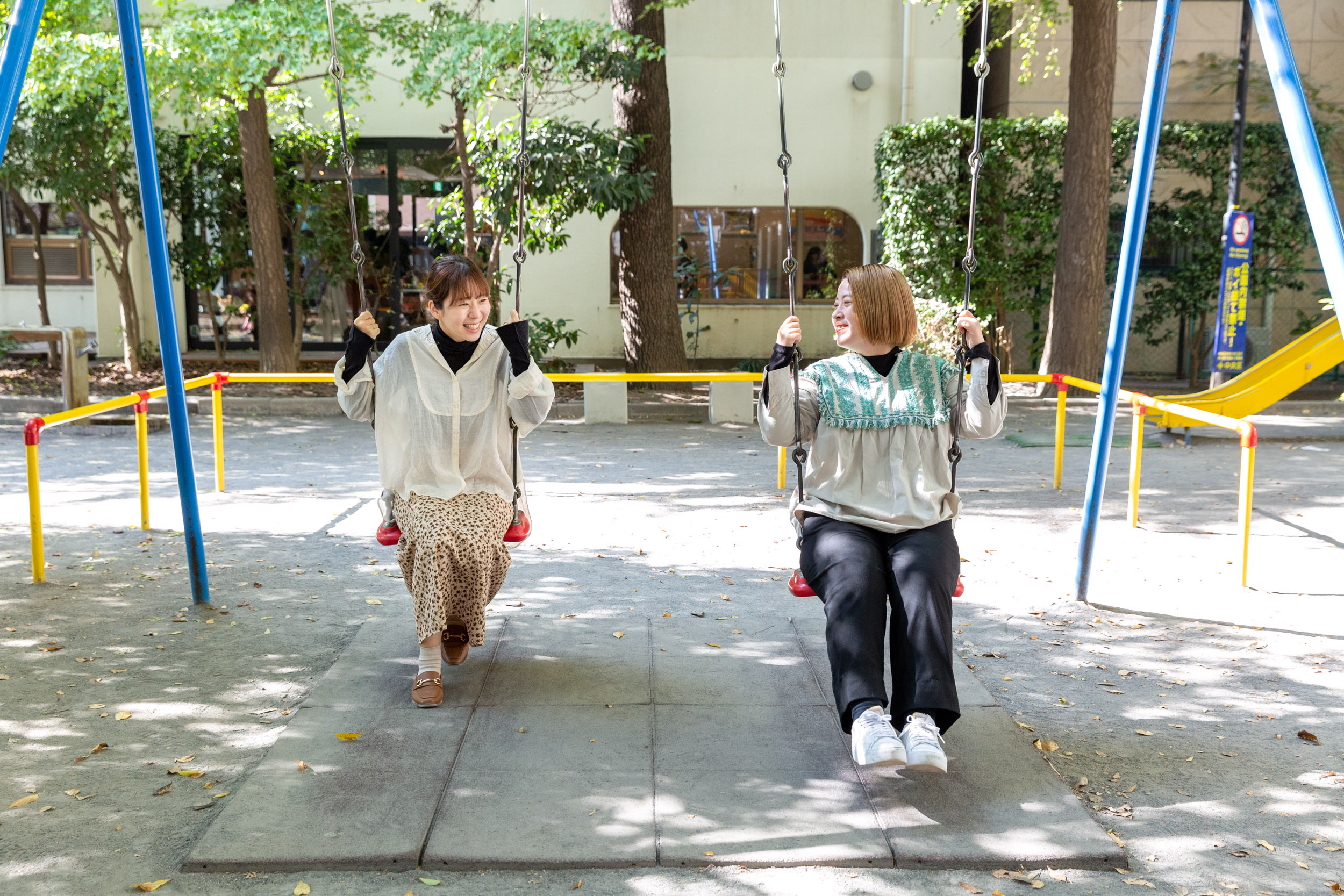 ブランコに座るCOTONのスタッフ二人